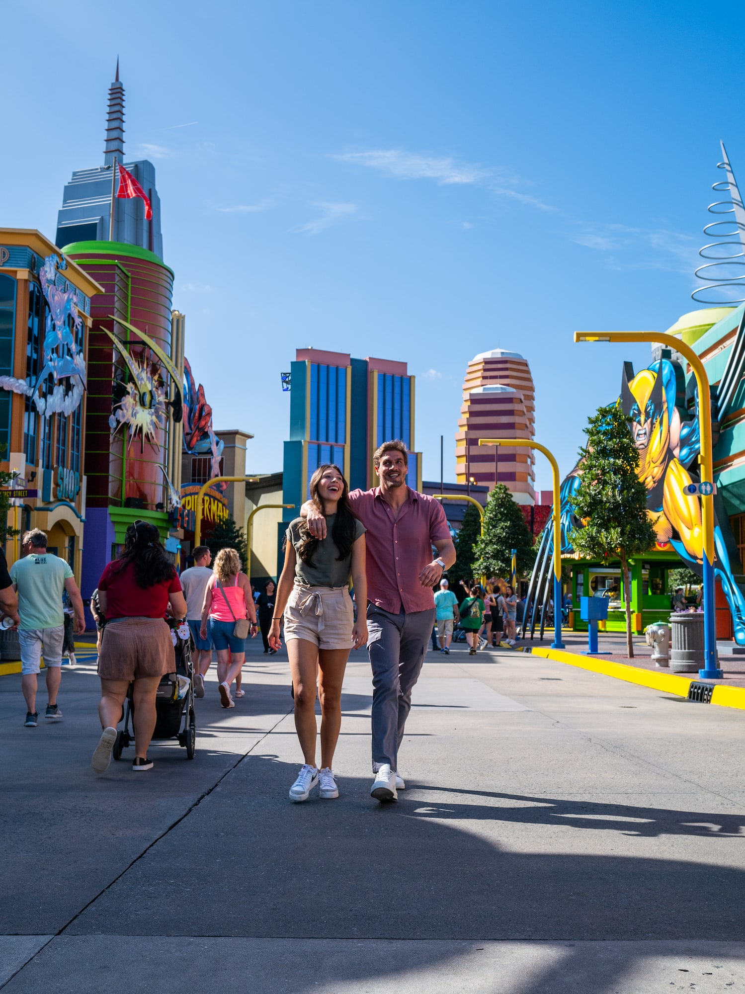 a man and woman walking in a street with colorful buildings