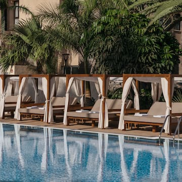 a pool with lounge chairs and canopy