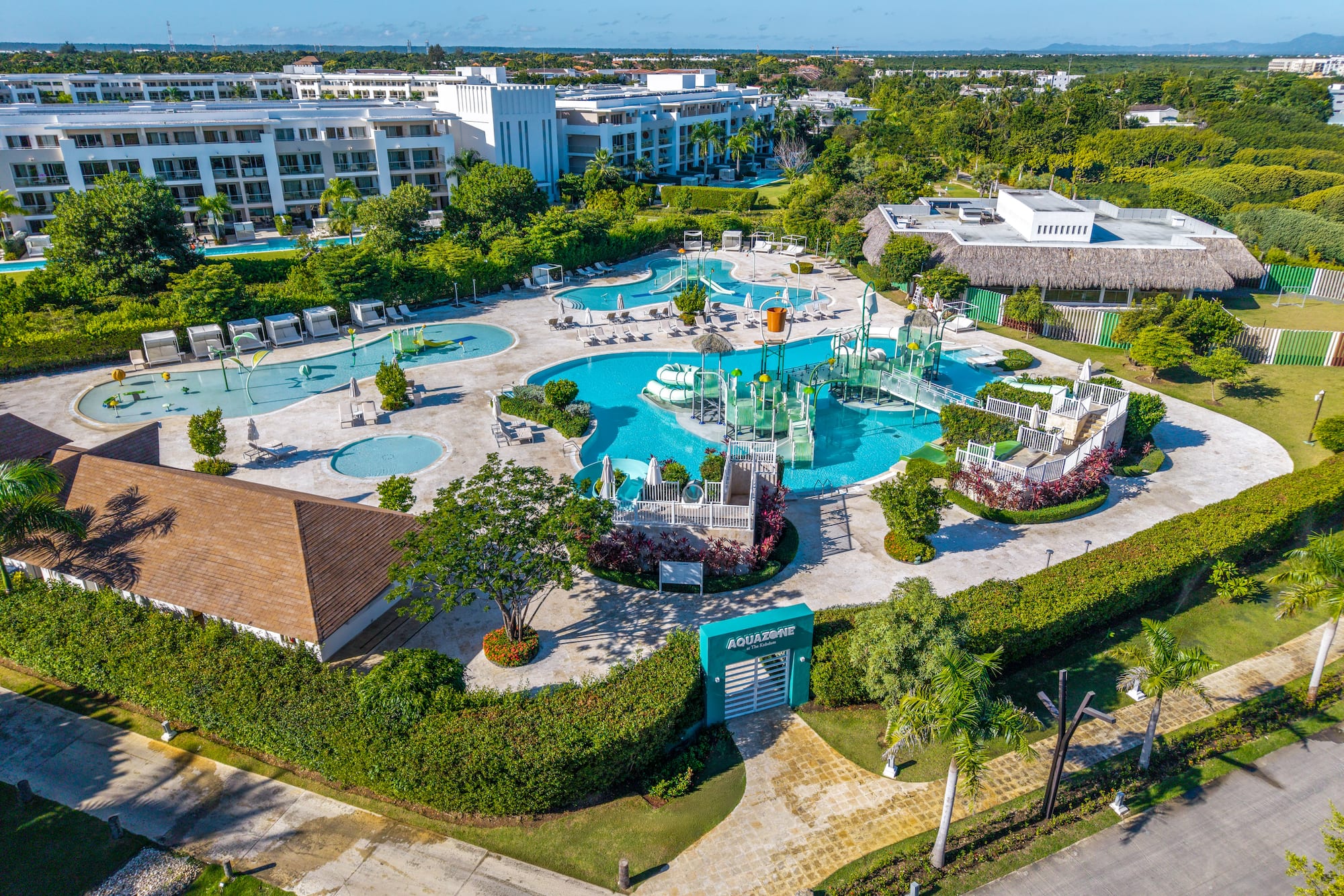 Aerial view: Tropical resort with large aquazone water park and multiple swimming pools.
