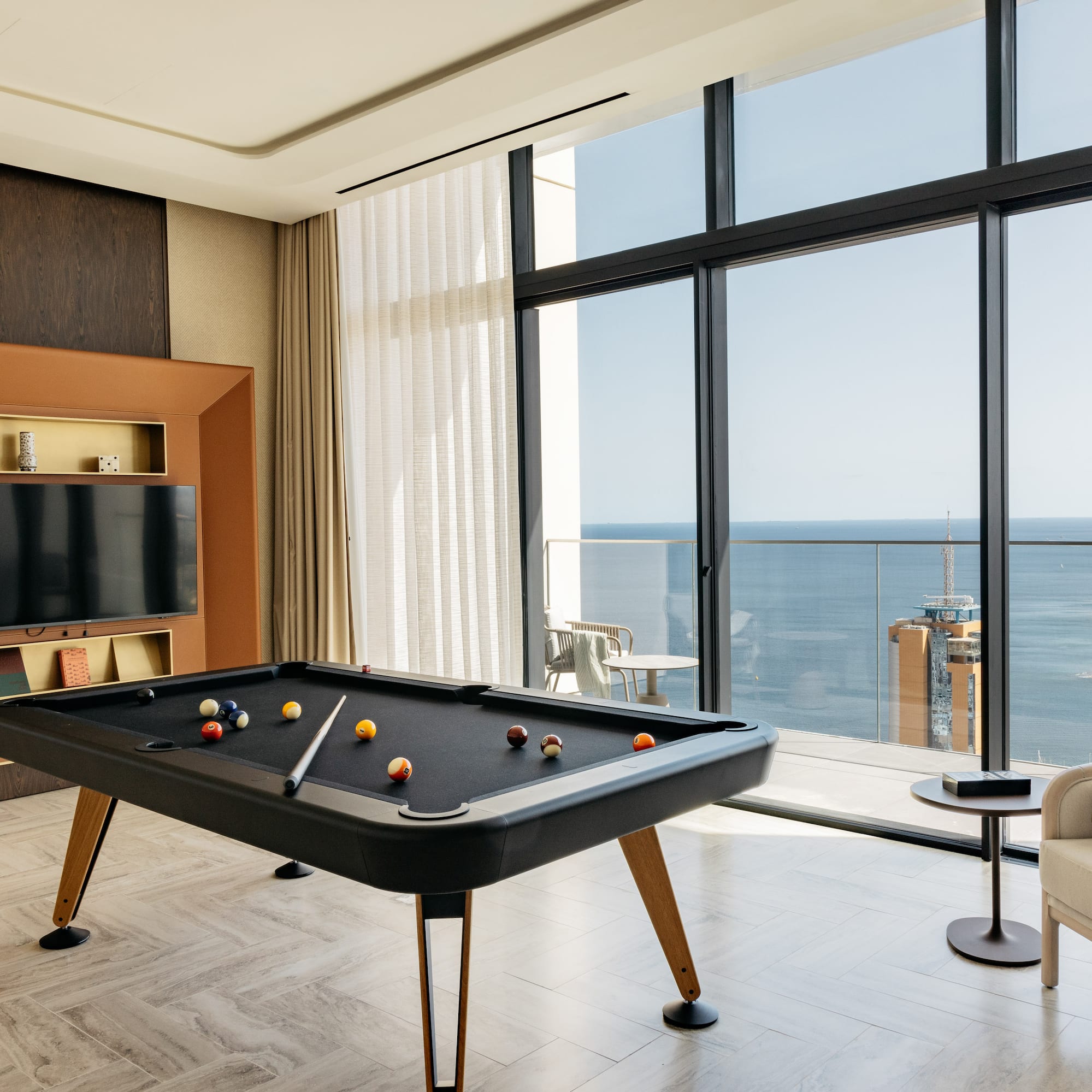 a pool table in a room with a television and a chair