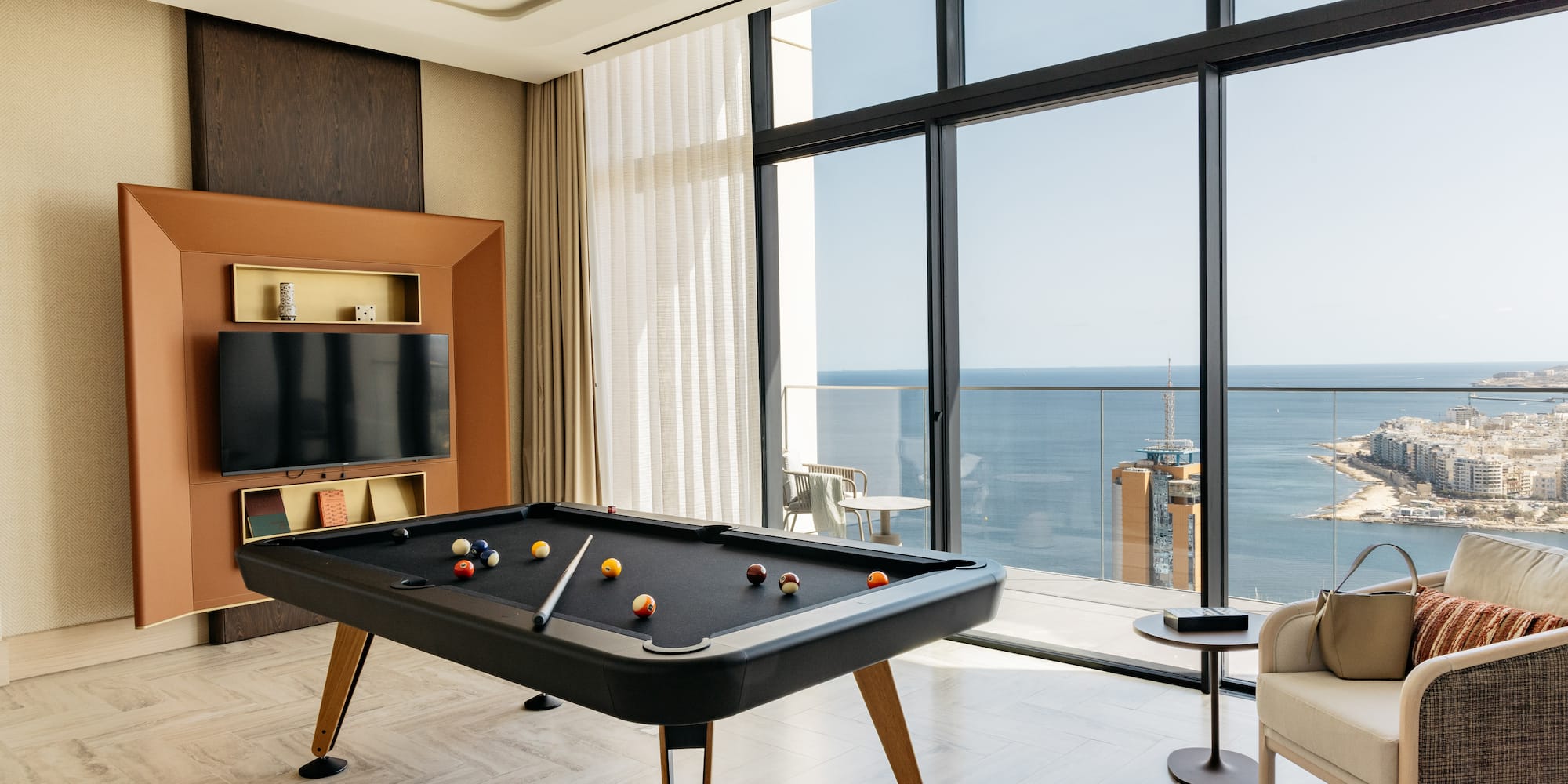 a pool table in a room with a television and a chair