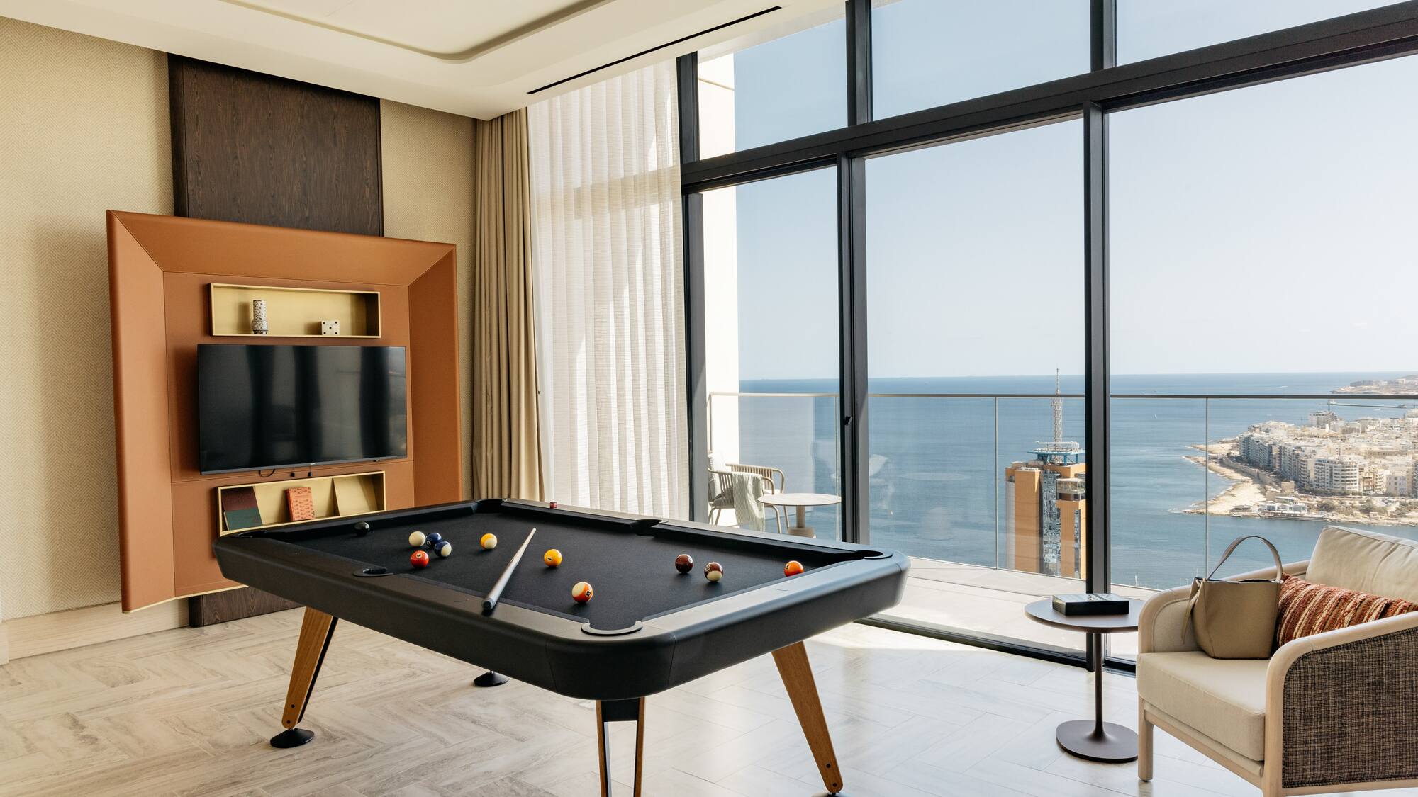 a pool table in a room with a television and a chair