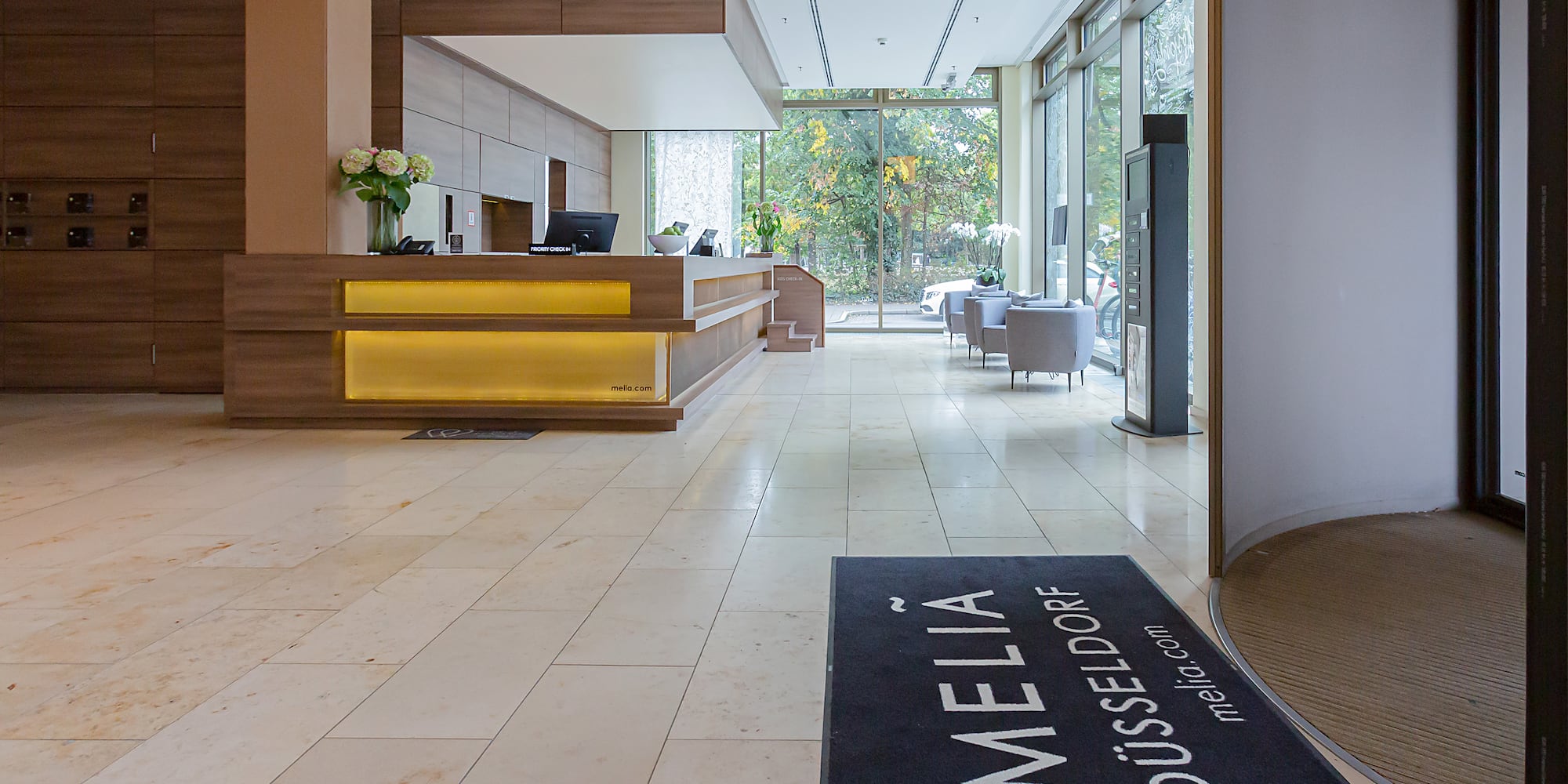 a lobby with a reception desk and a black mat