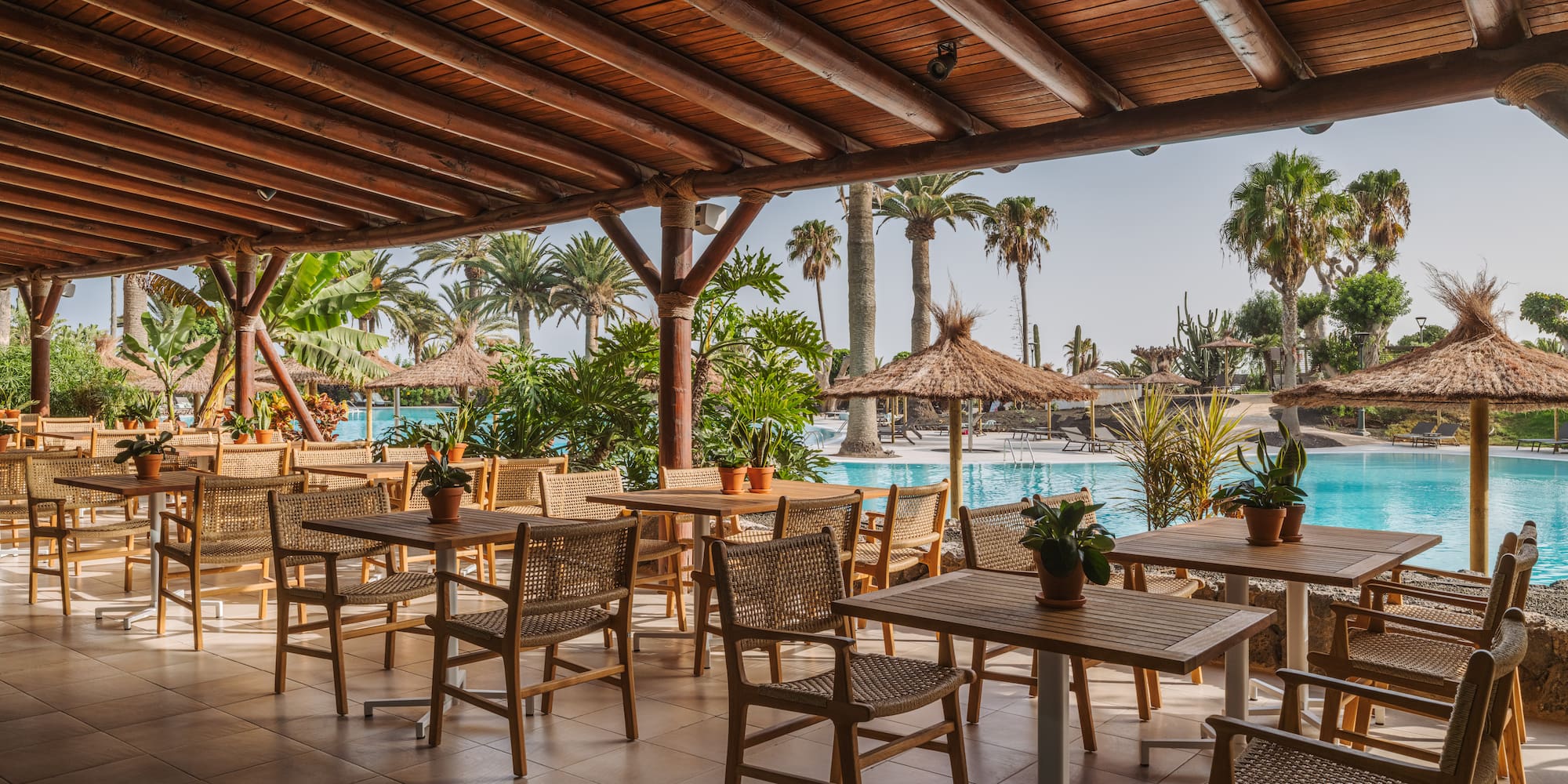 a patio with tables and chairs and a pool