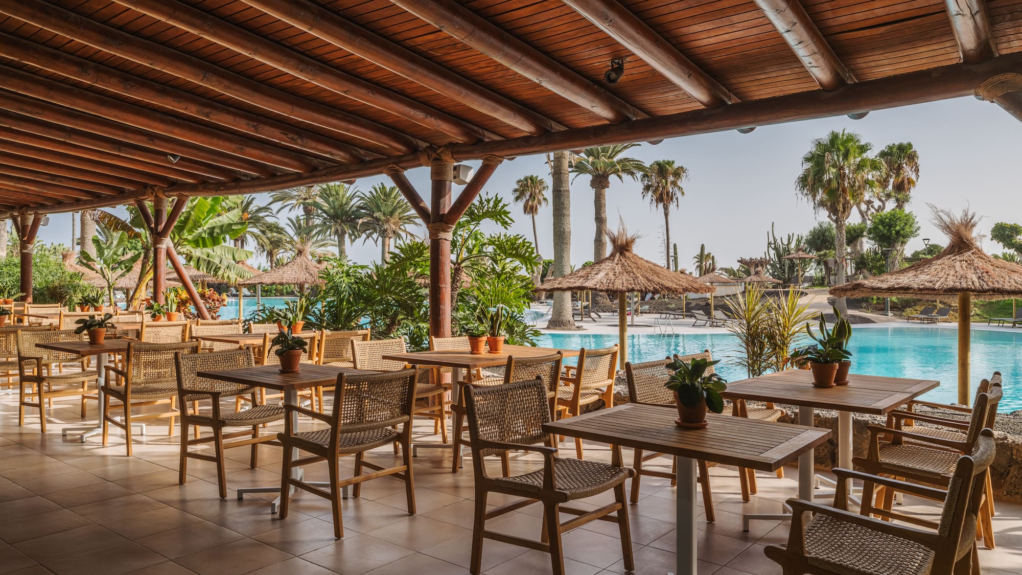 a patio with tables and chairs and a pool
