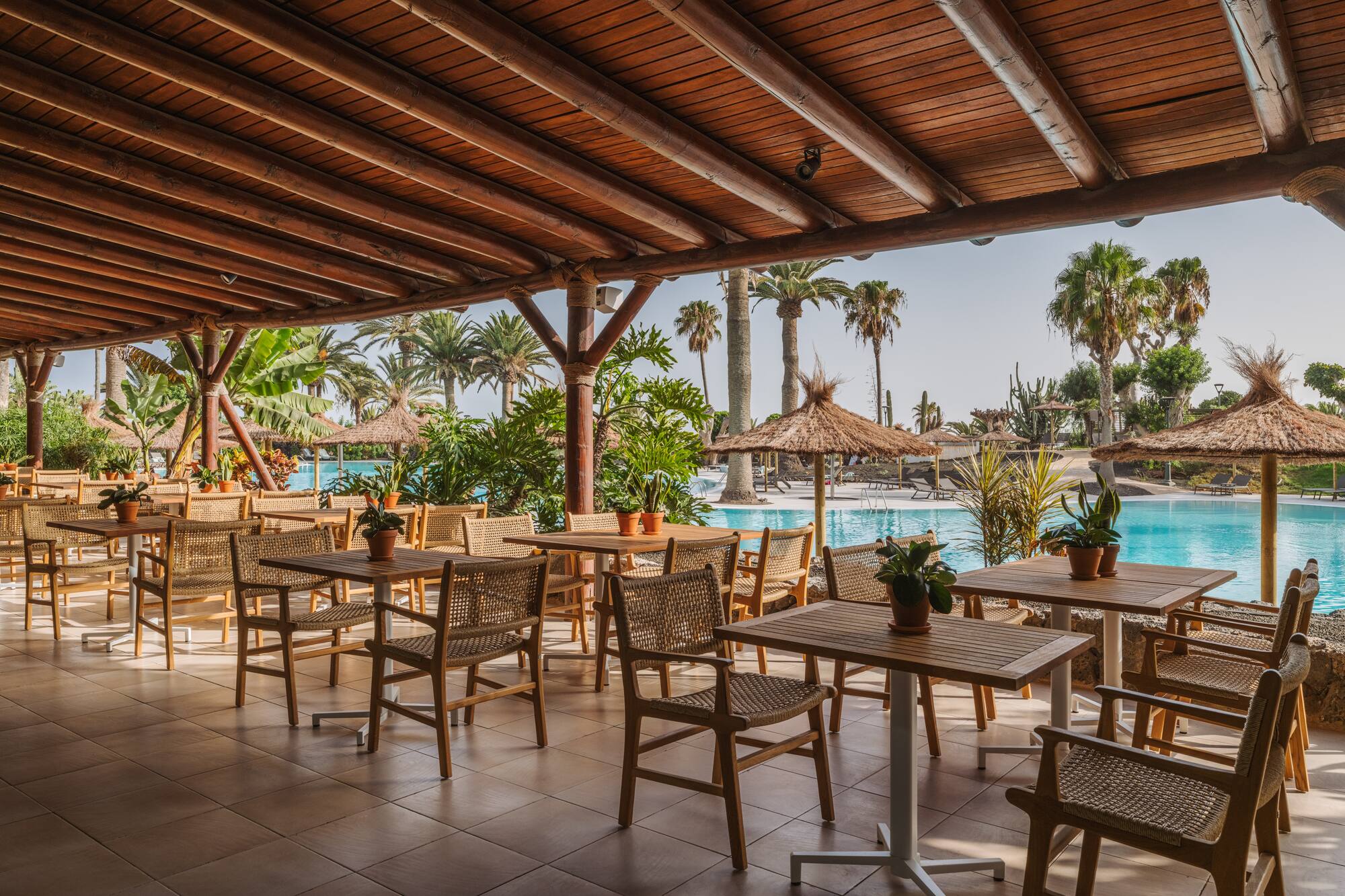 a patio with tables and chairs and a pool