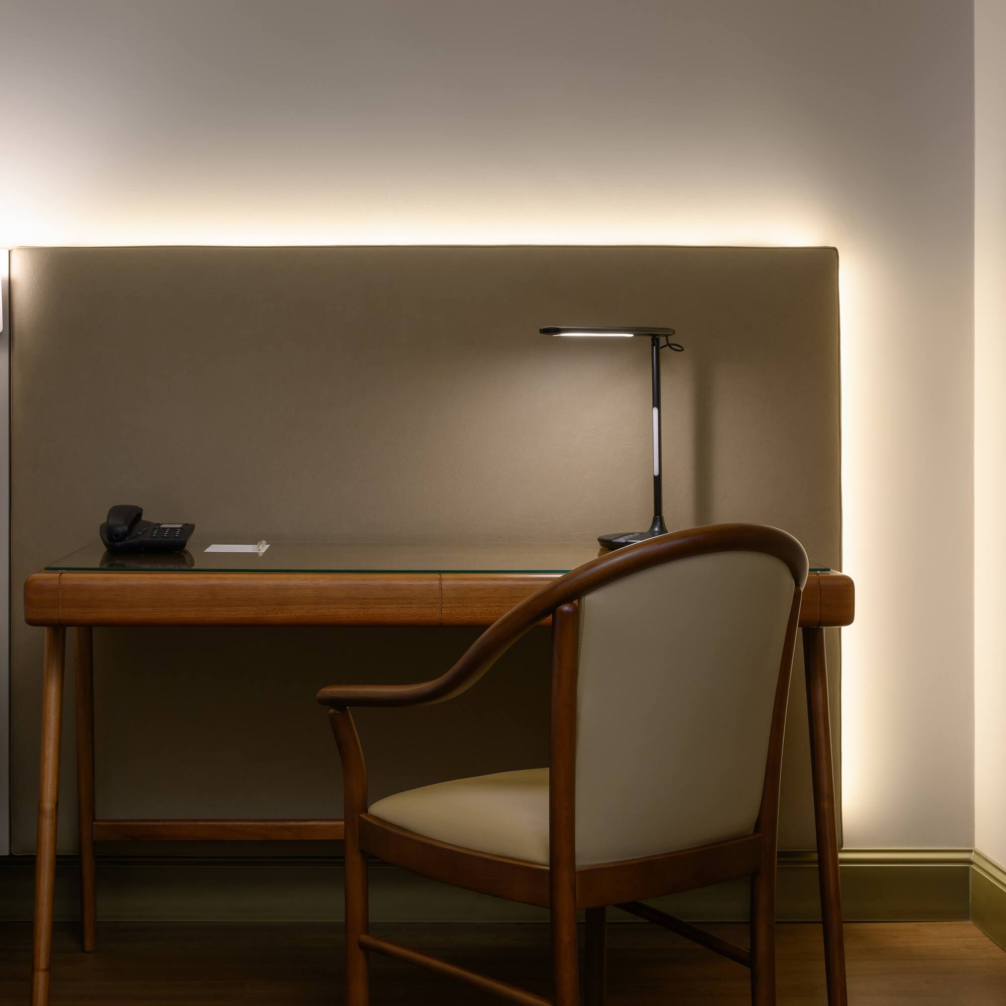 a desk with a chair and a lamp