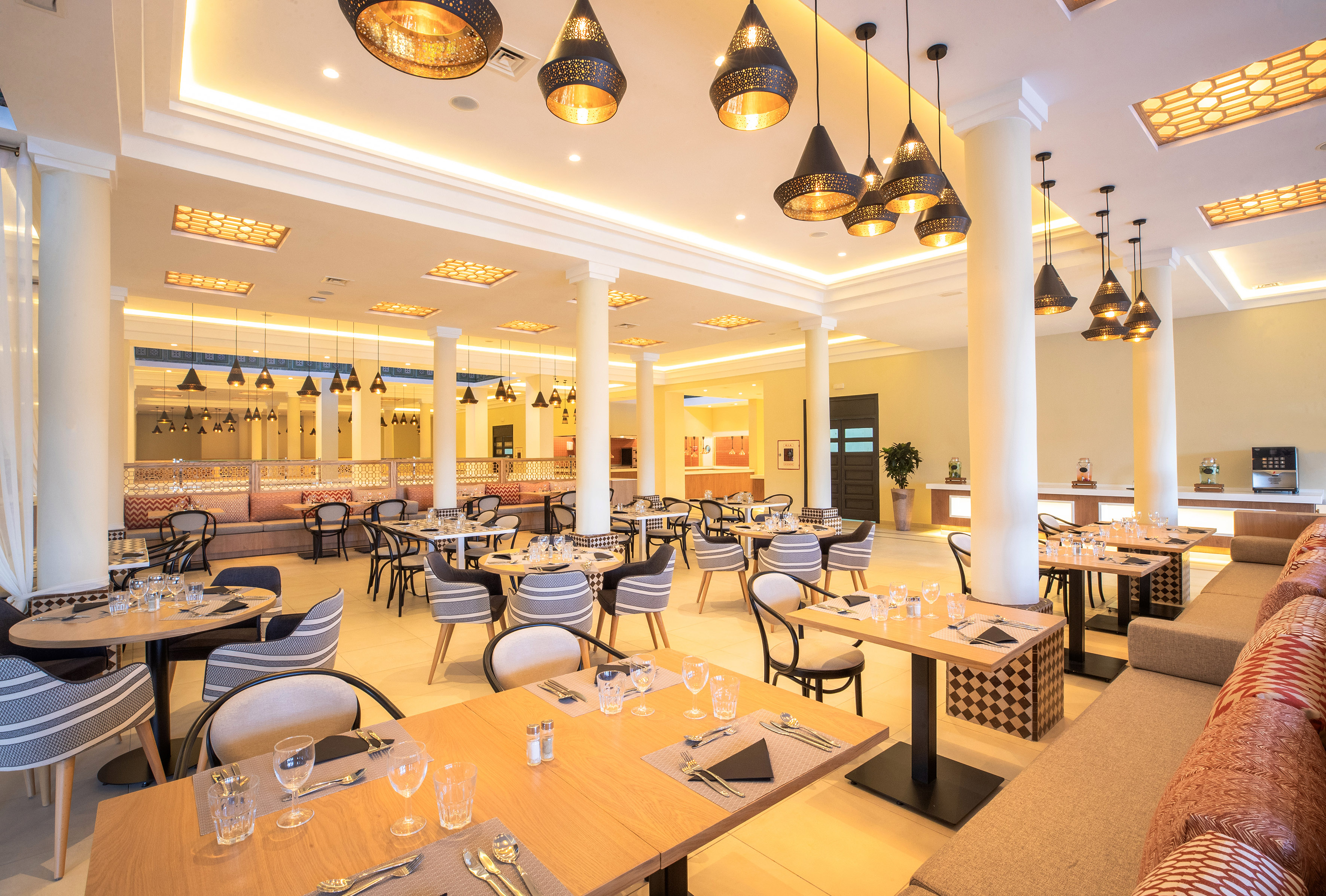 Elegant hotel restaurant dining room with Moroccan lamps and modern decor.