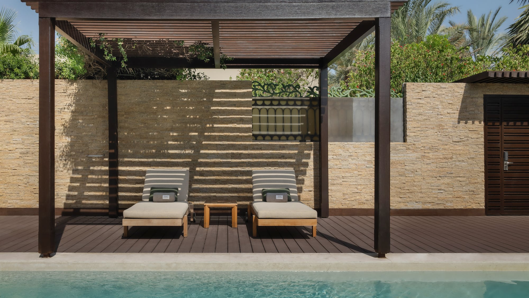 a pool with lounge chairs and a wood deck