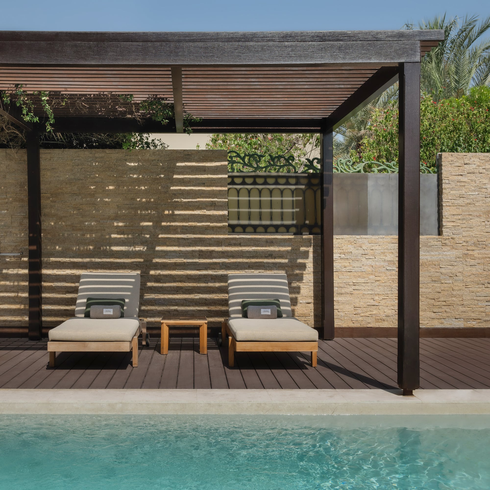 a pool with lounge chairs and a wood deck