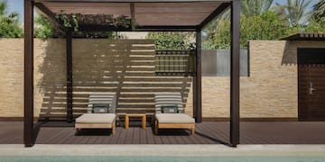 a pool with lounge chairs and a wood deck