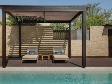 a pool with lounge chairs and a wood deck