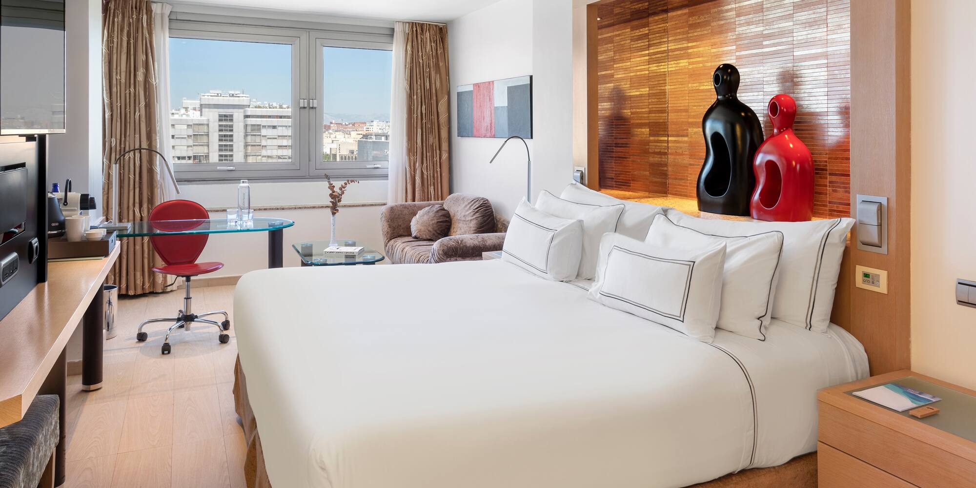 a room with a bed and a desk and chairs