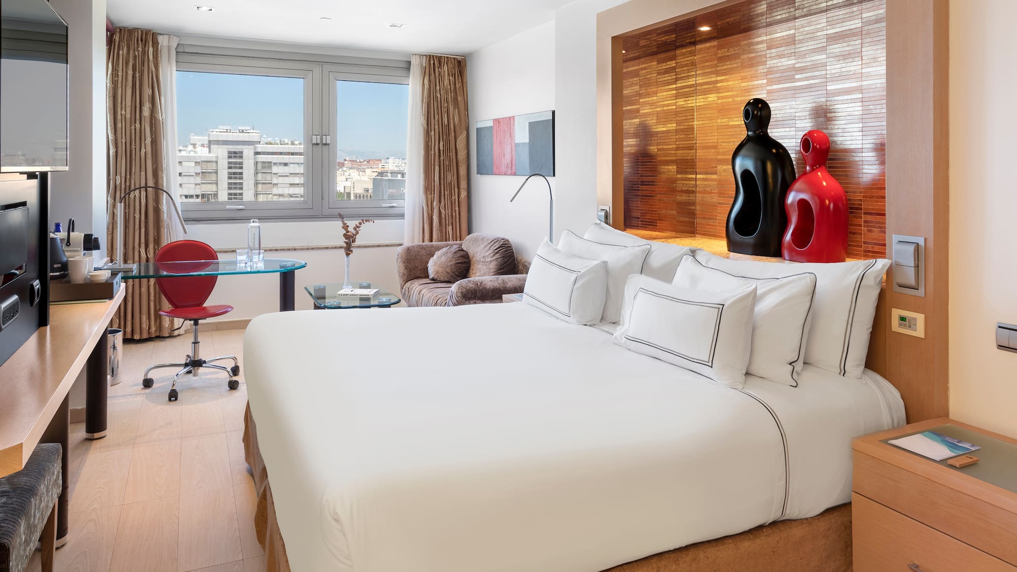 a room with a bed and a desk and chairs