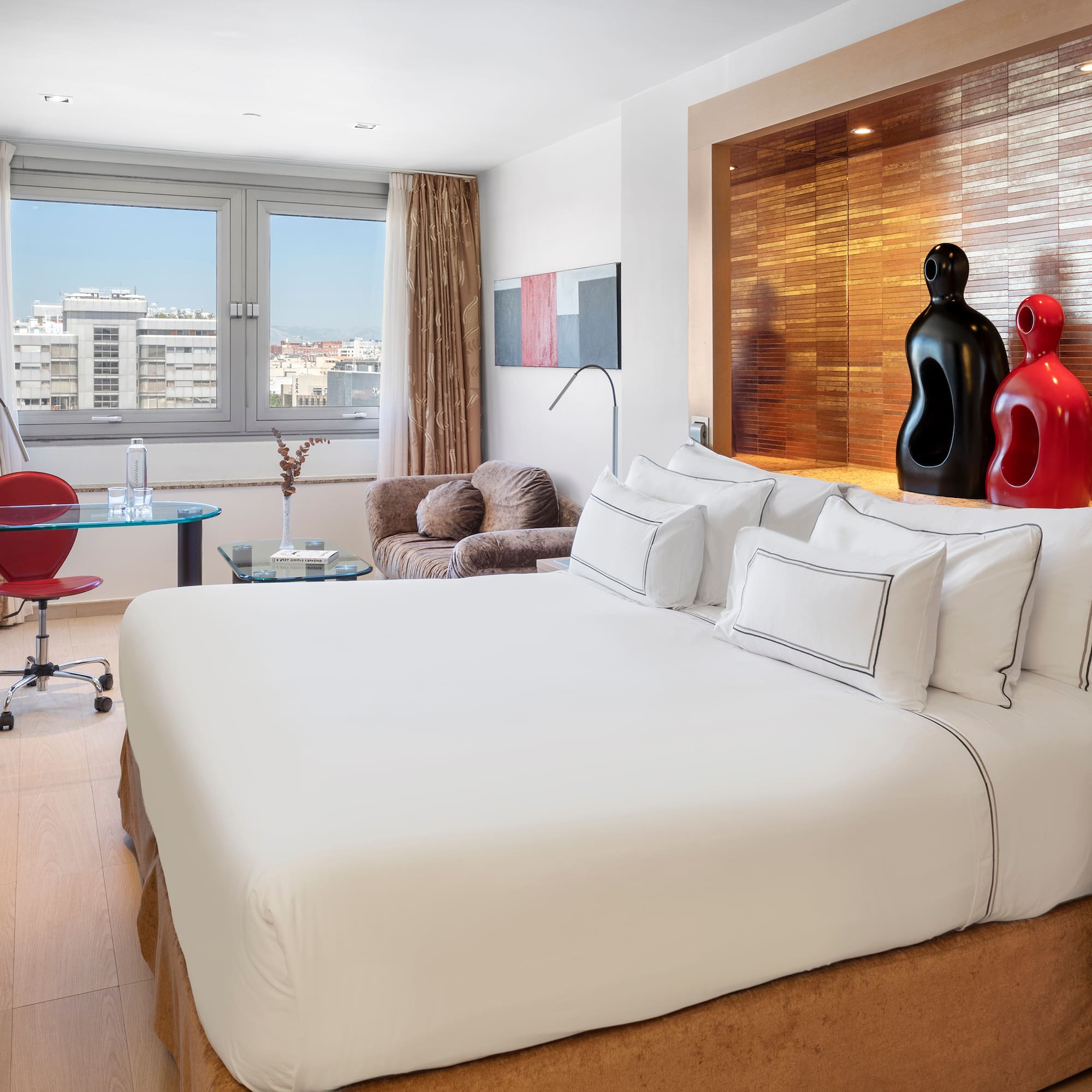 a room with a bed and a desk and chairs