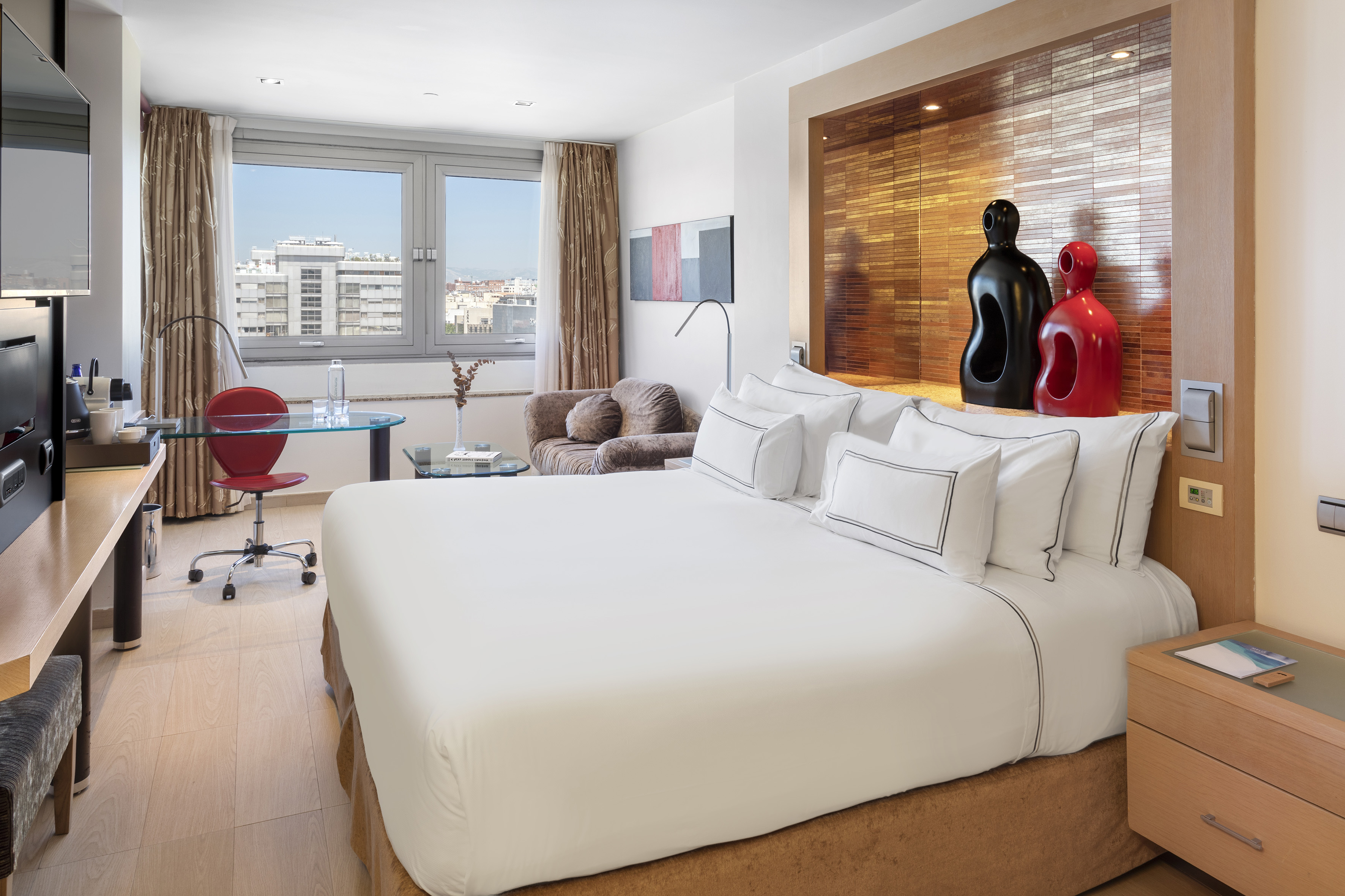 a room with a bed and a desk and chairs