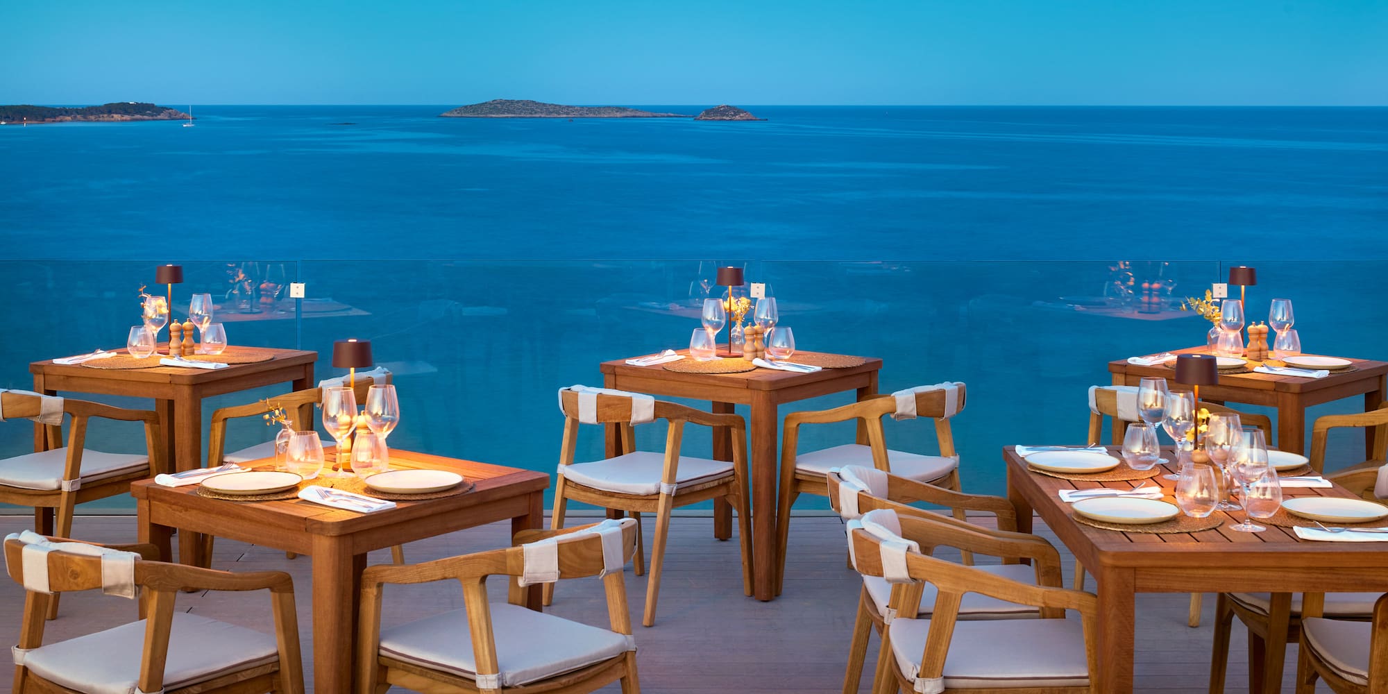 a table and chairs with a view of the ocean