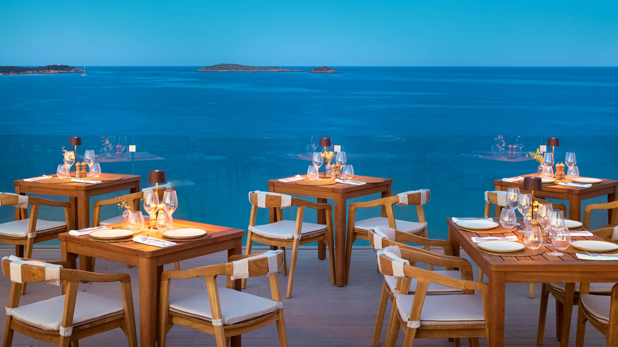 a table and chairs with a view of the ocean
