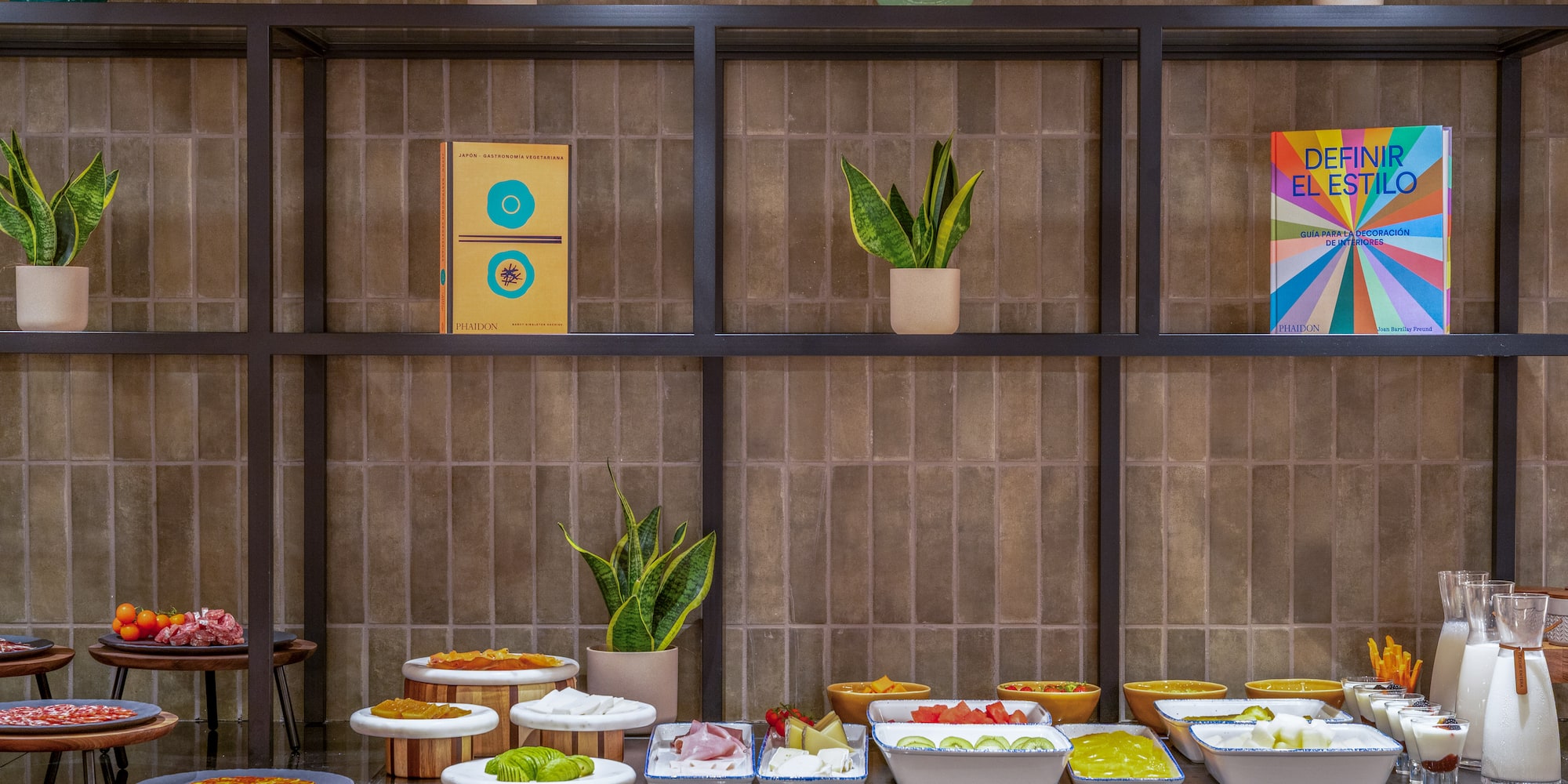 Buffet de desayuno con alimentos frescos, frutas, lácteos y decoración.