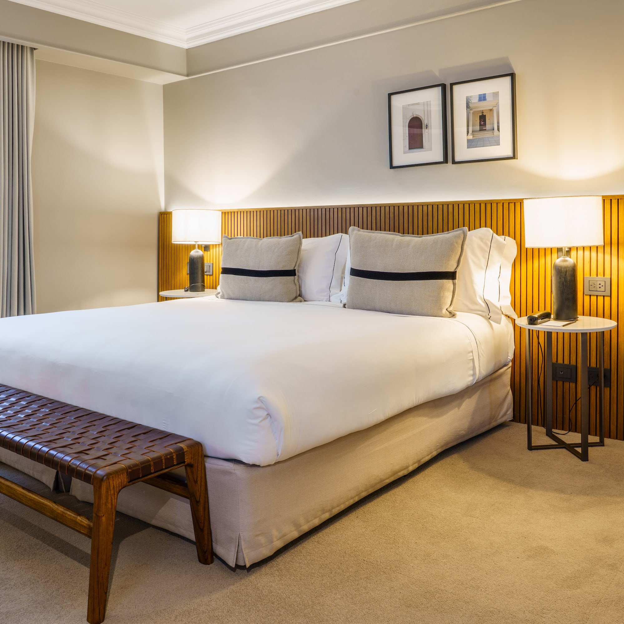 a bed with a bench and lamps in a room