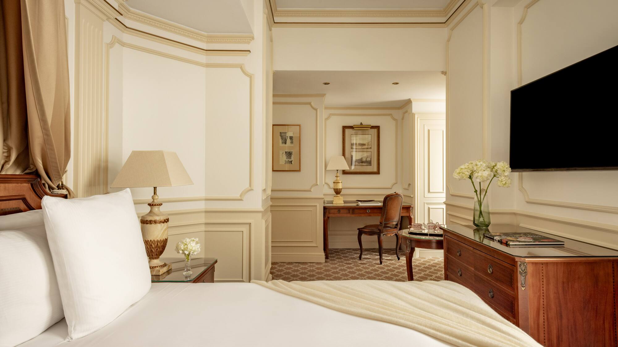 a bedroom with a white bed and a desk