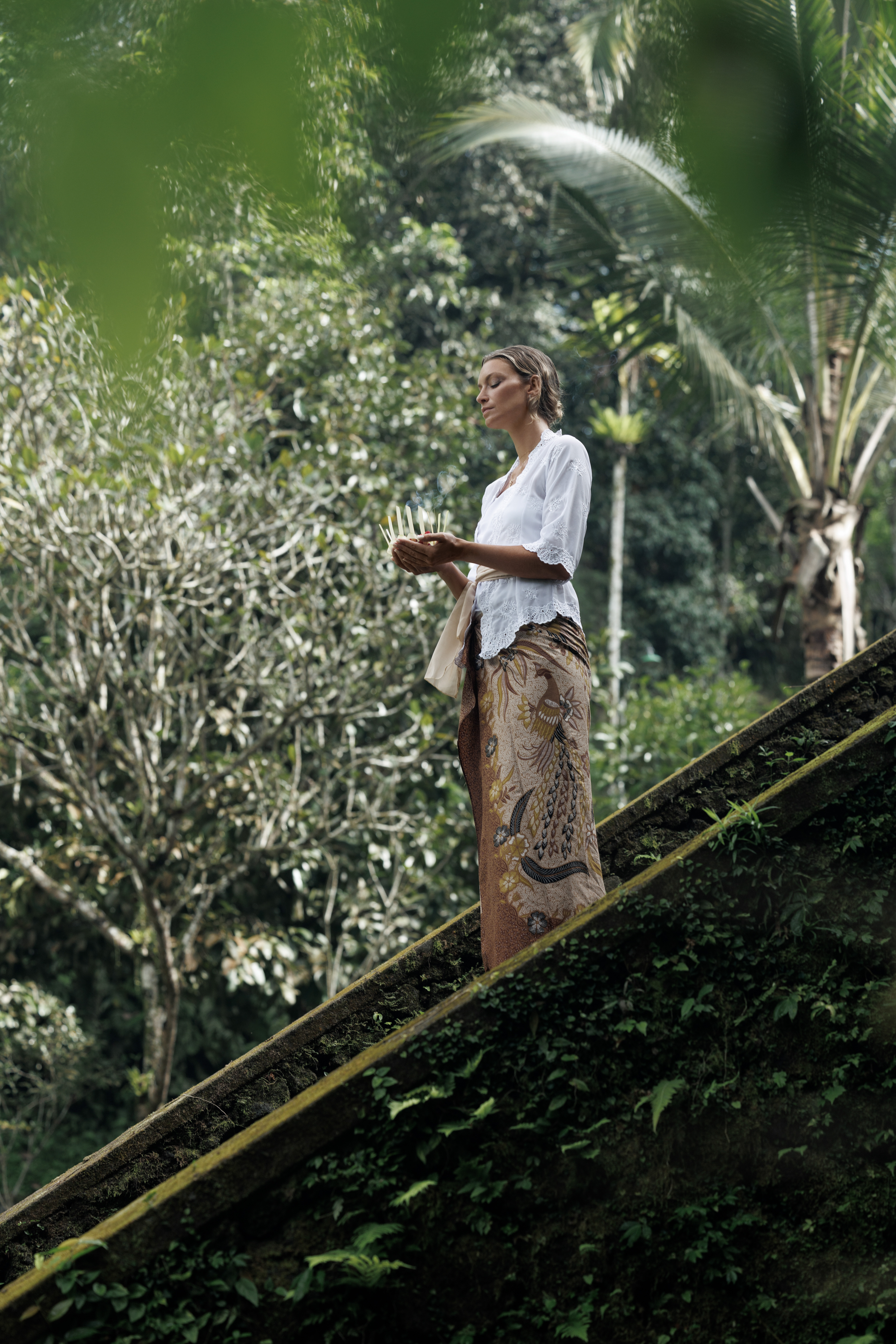 a woman holding candles on stairs