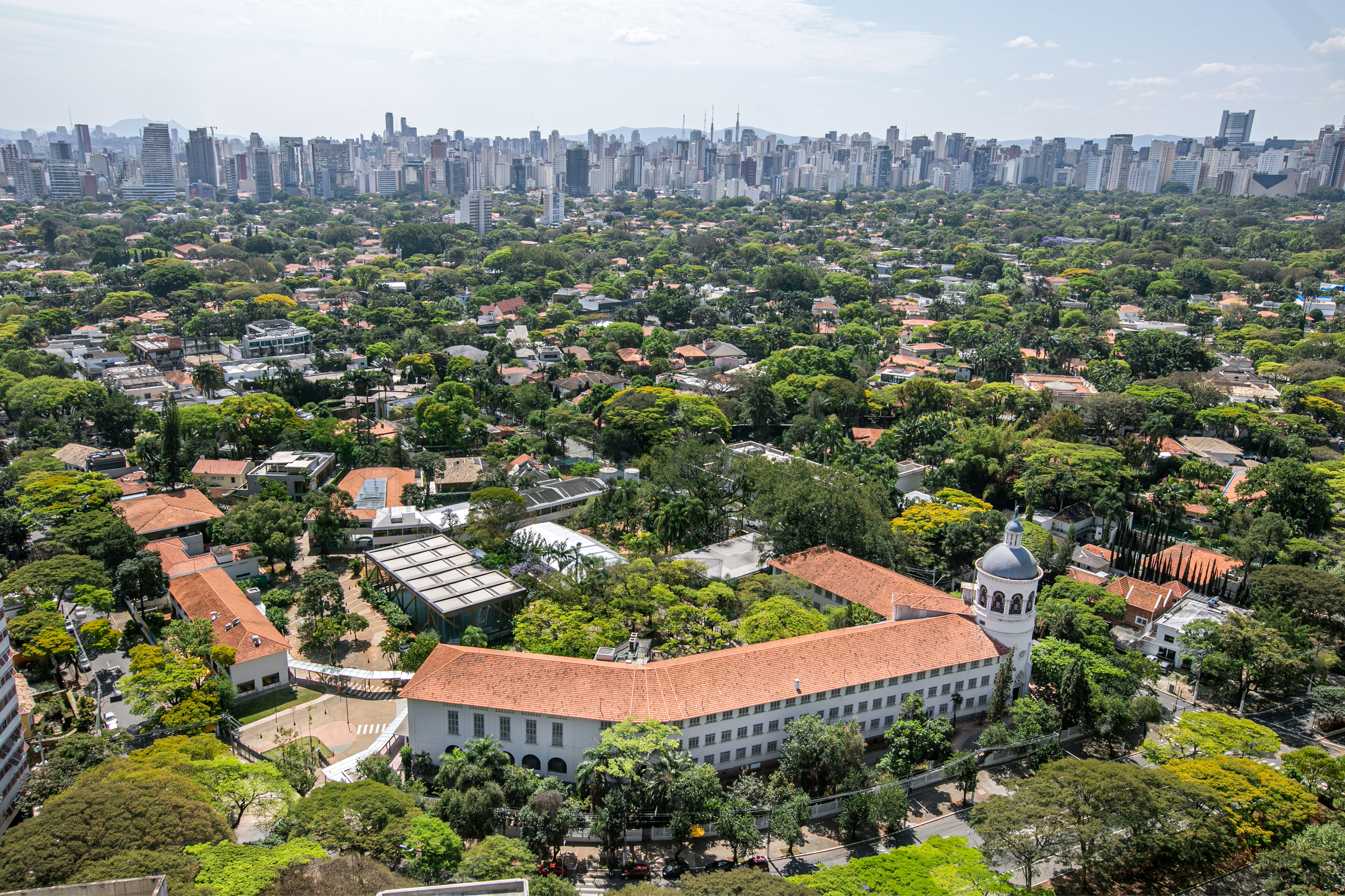 a large building with trees and a city in the background
