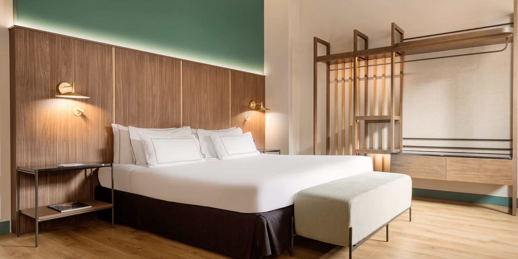 a bed with white sheets and a bench in a room