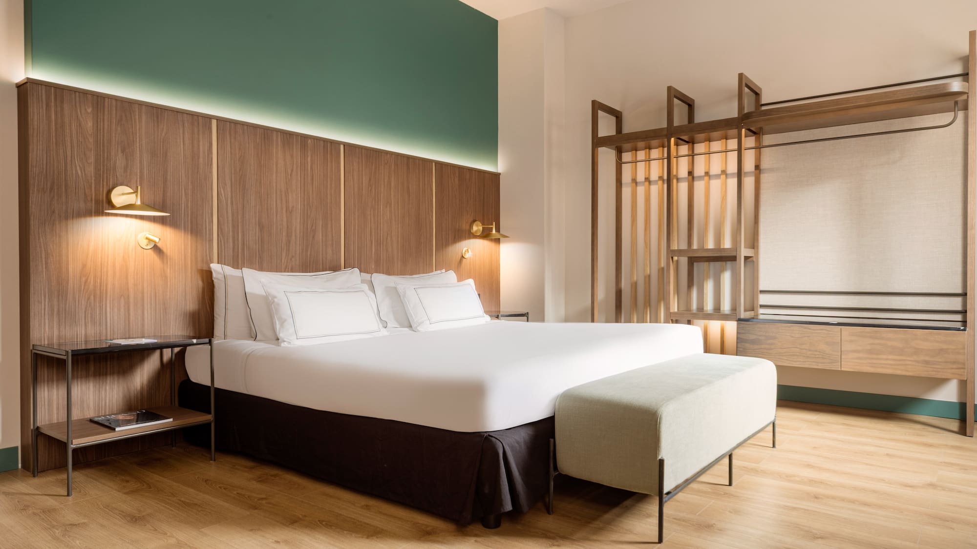 a bed with white sheets and a bench in a room