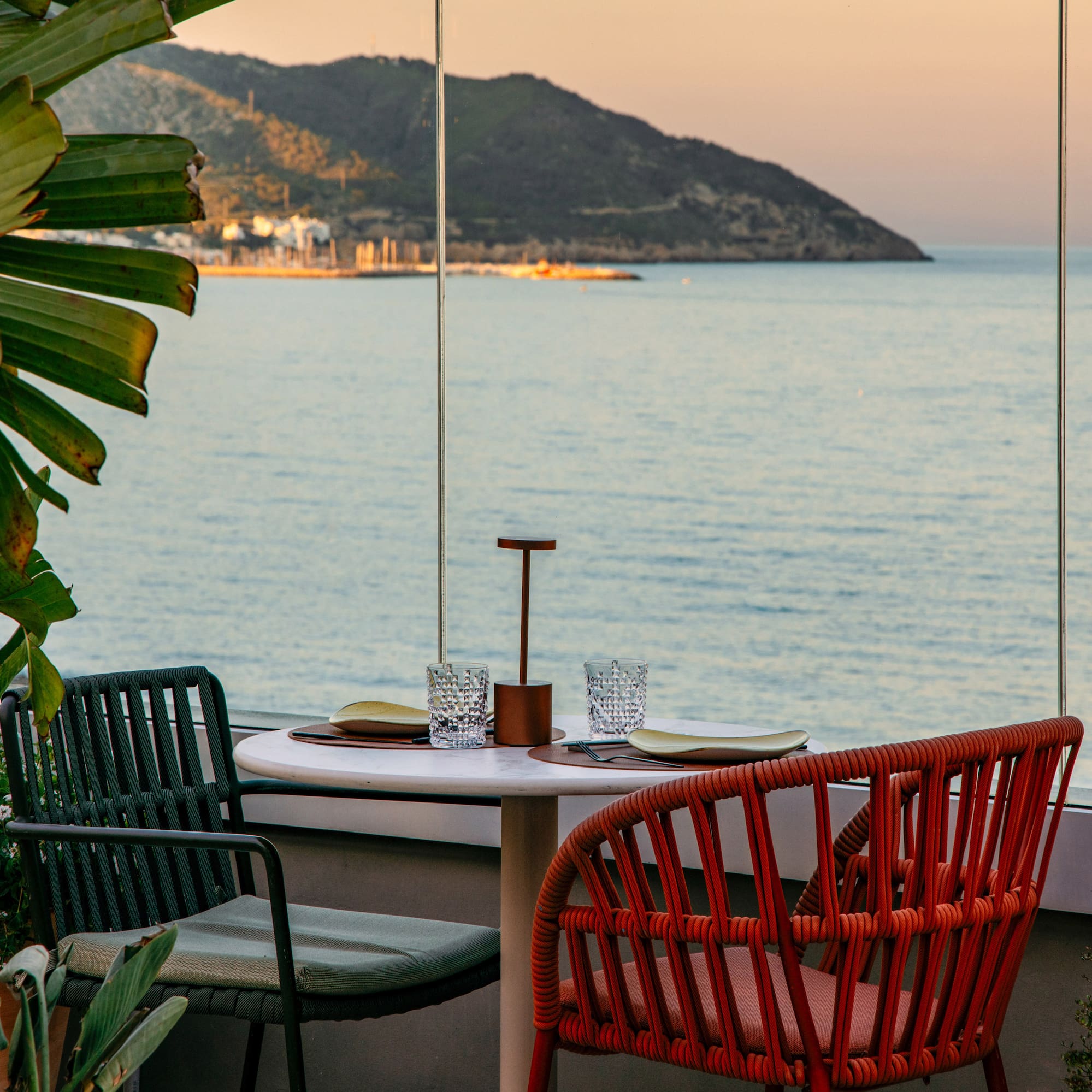 a table with chairs and a view of the ocean