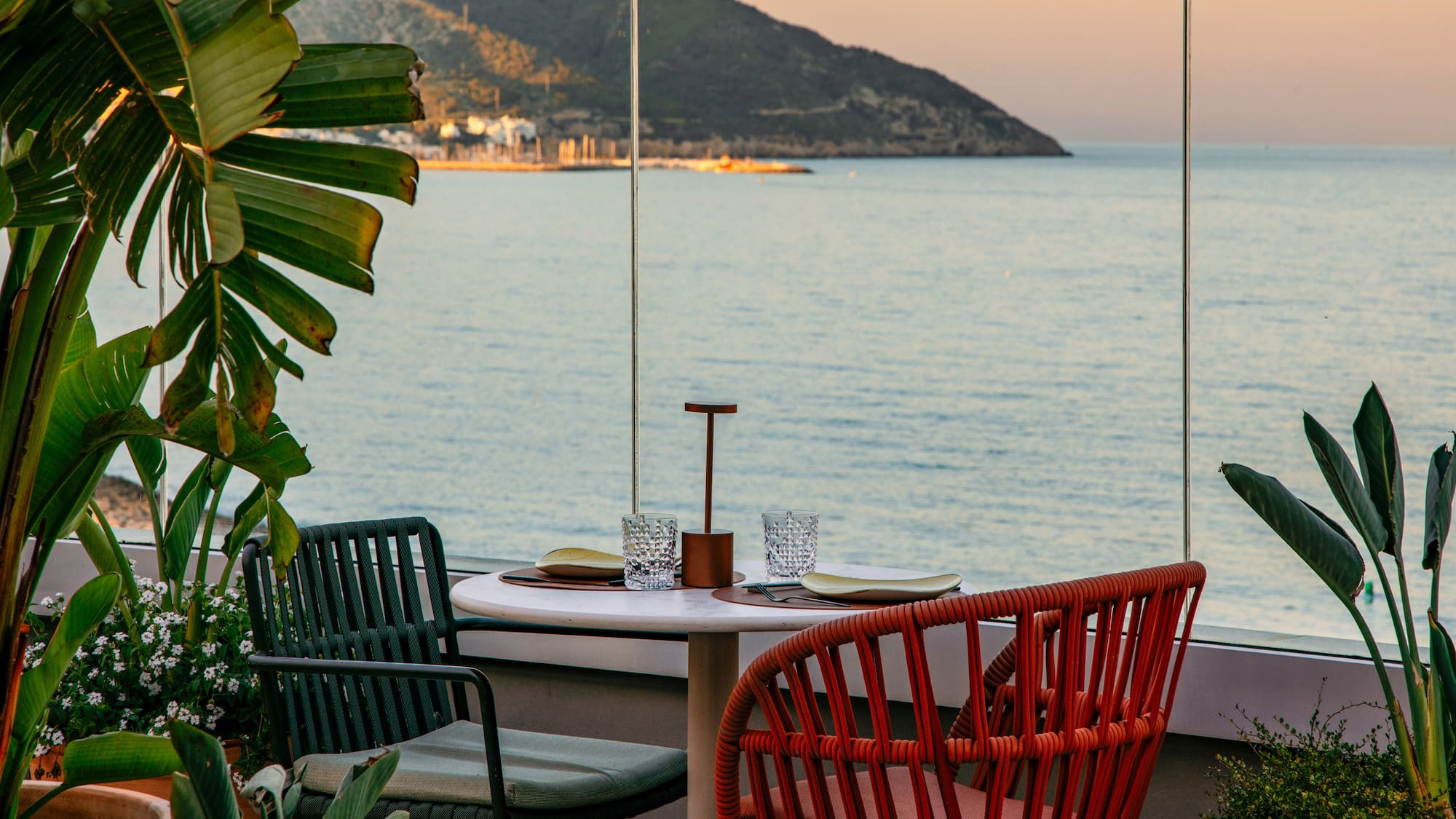 a table with chairs and a view of the ocean