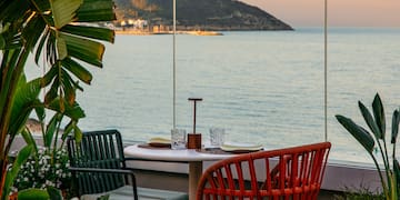 a table with chairs and a view of the ocean