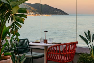 a table with chairs and a view of the ocean