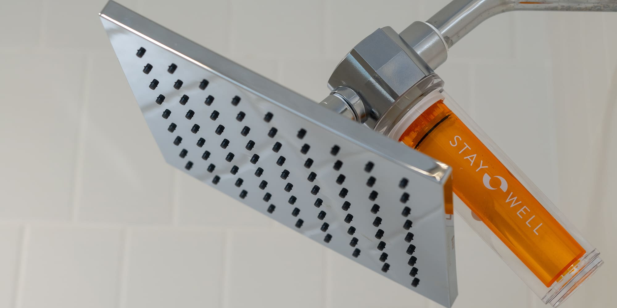 a shower head with orange liquid