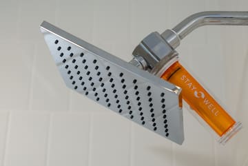 a shower head with orange liquid