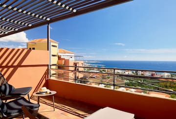 a balcony with a view of the ocean and a city