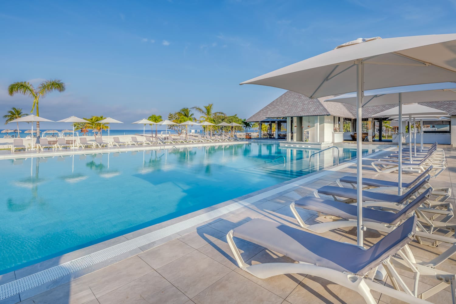 a pool with lounge chairs and umbrellas