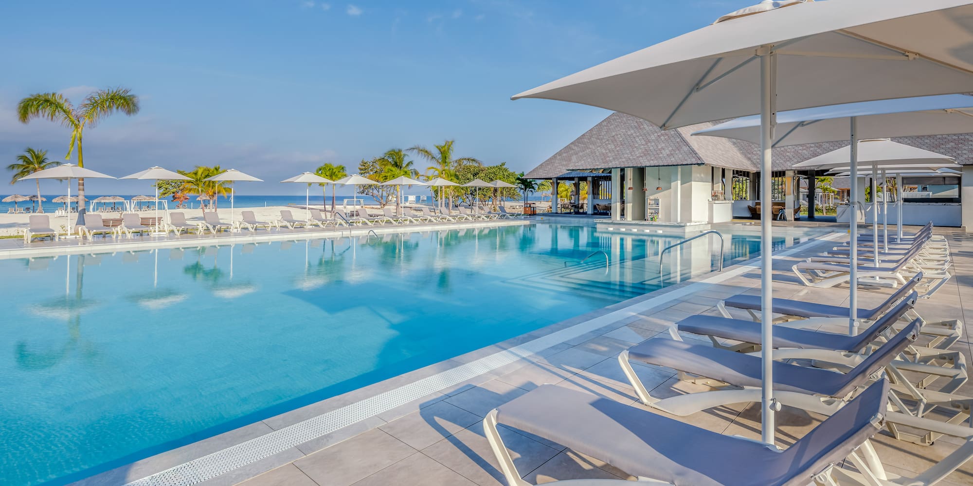 a pool with lounge chairs and umbrellas