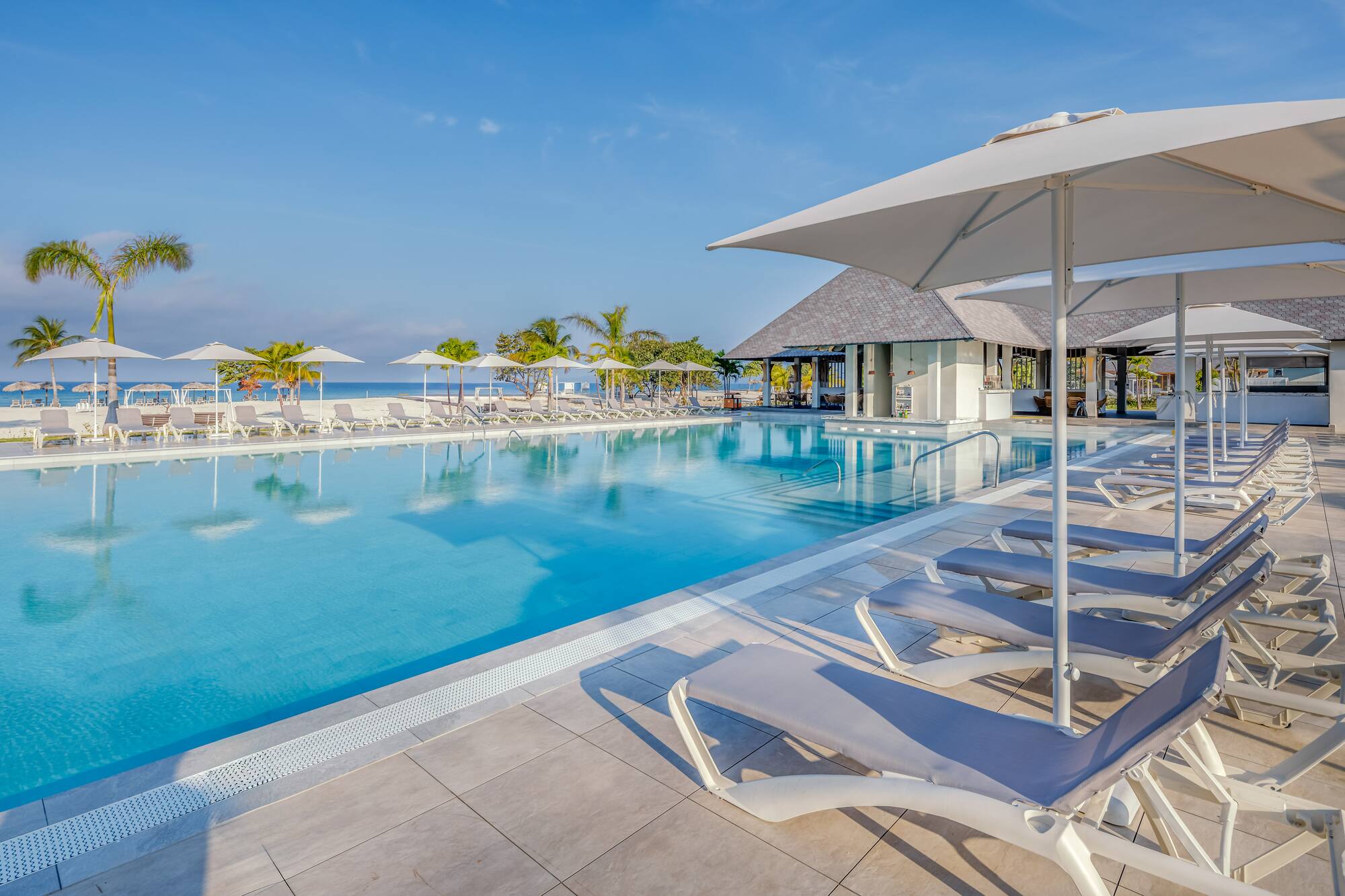 a pool with lounge chairs and umbrellas