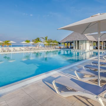 a pool with lounge chairs and umbrellas