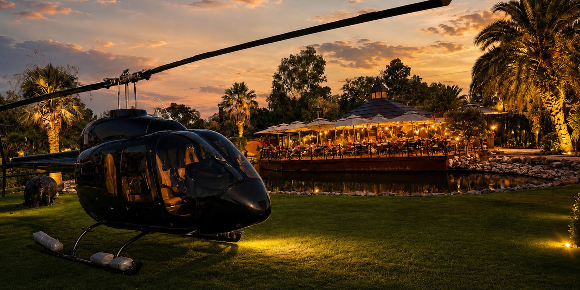 Black helicopter parked at luxury resort restaurant during golden sunset.