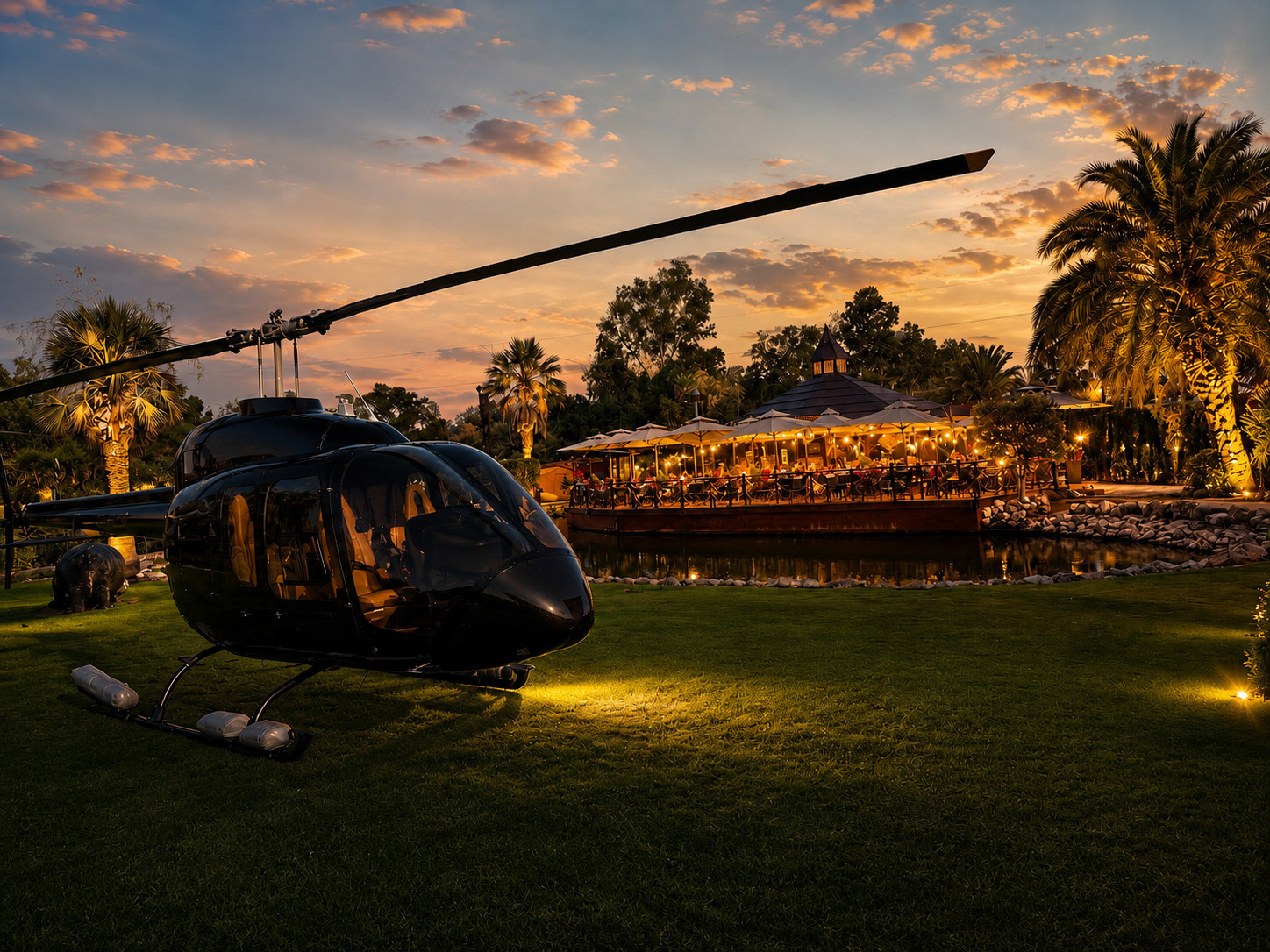 Black helicopter parked at luxury resort restaurant during golden sunset.