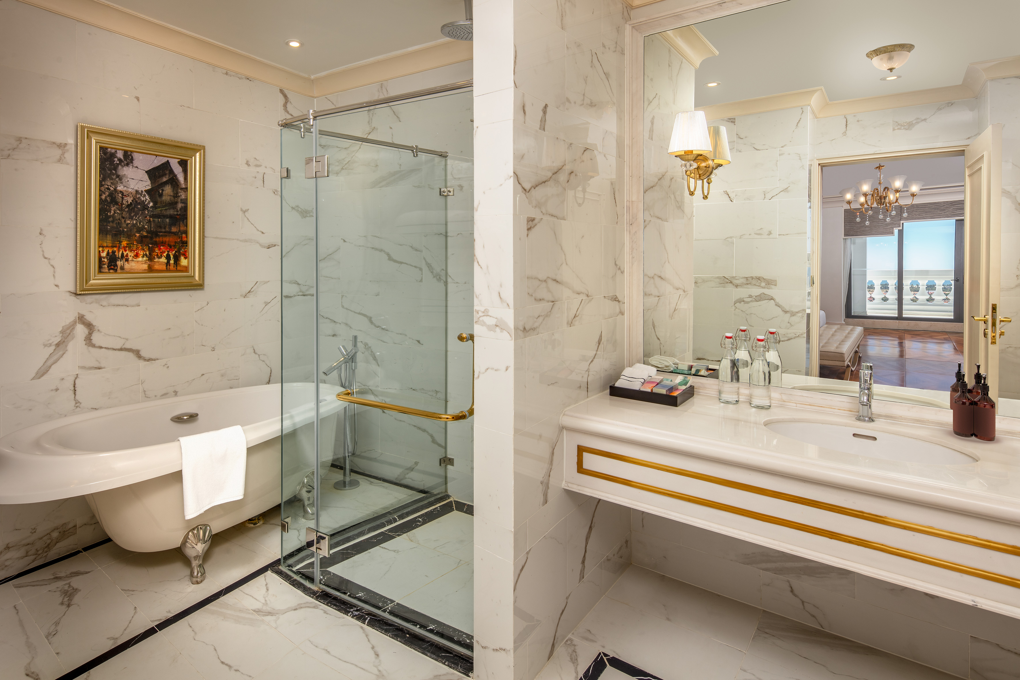 Elegant marble bathroom with clawfoot tub, glass shower, and vanity.