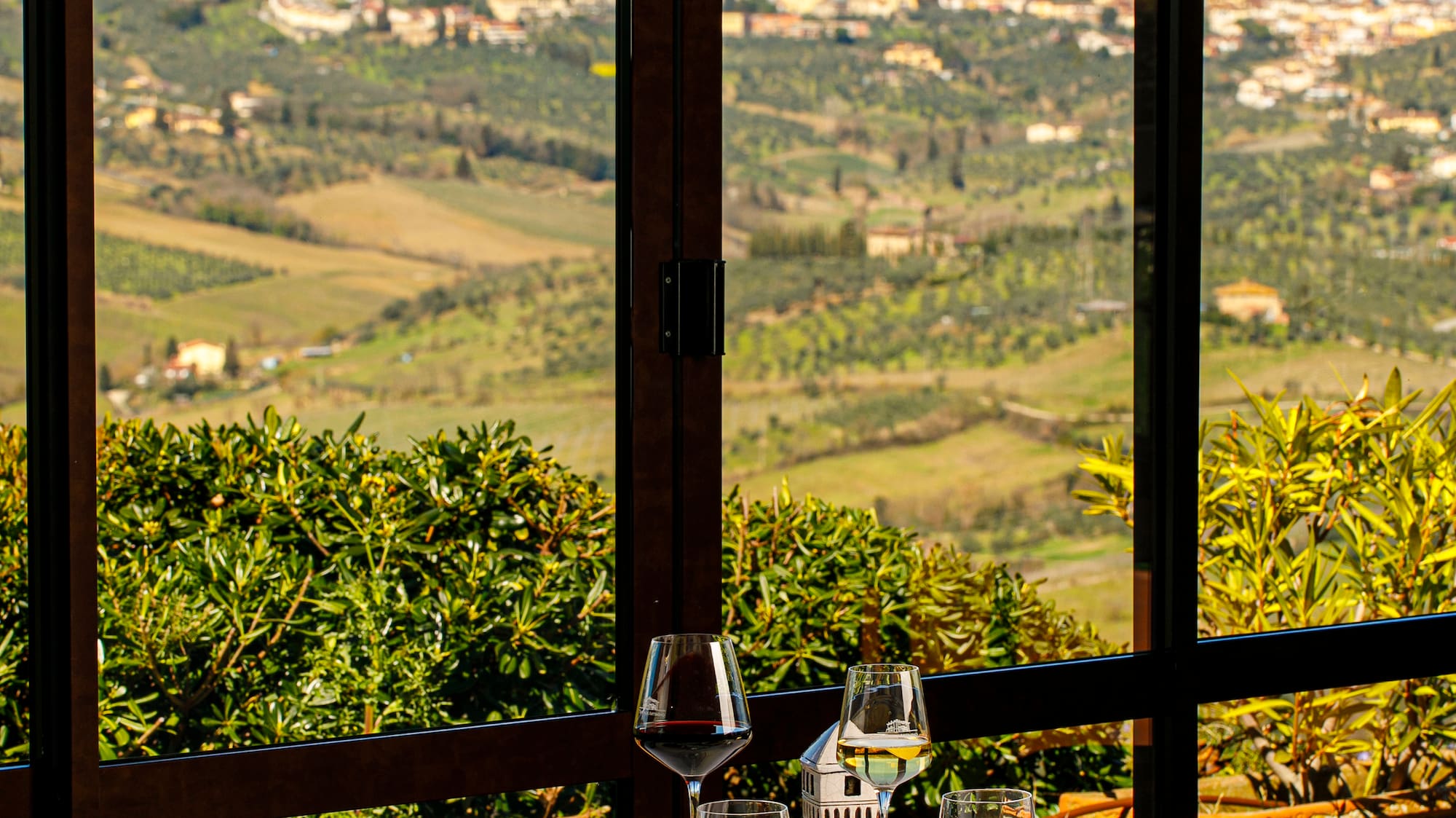 a table with food and glasses on it outside with a view of a valley