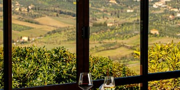 a table with food and glasses on it outside with a view of a valley