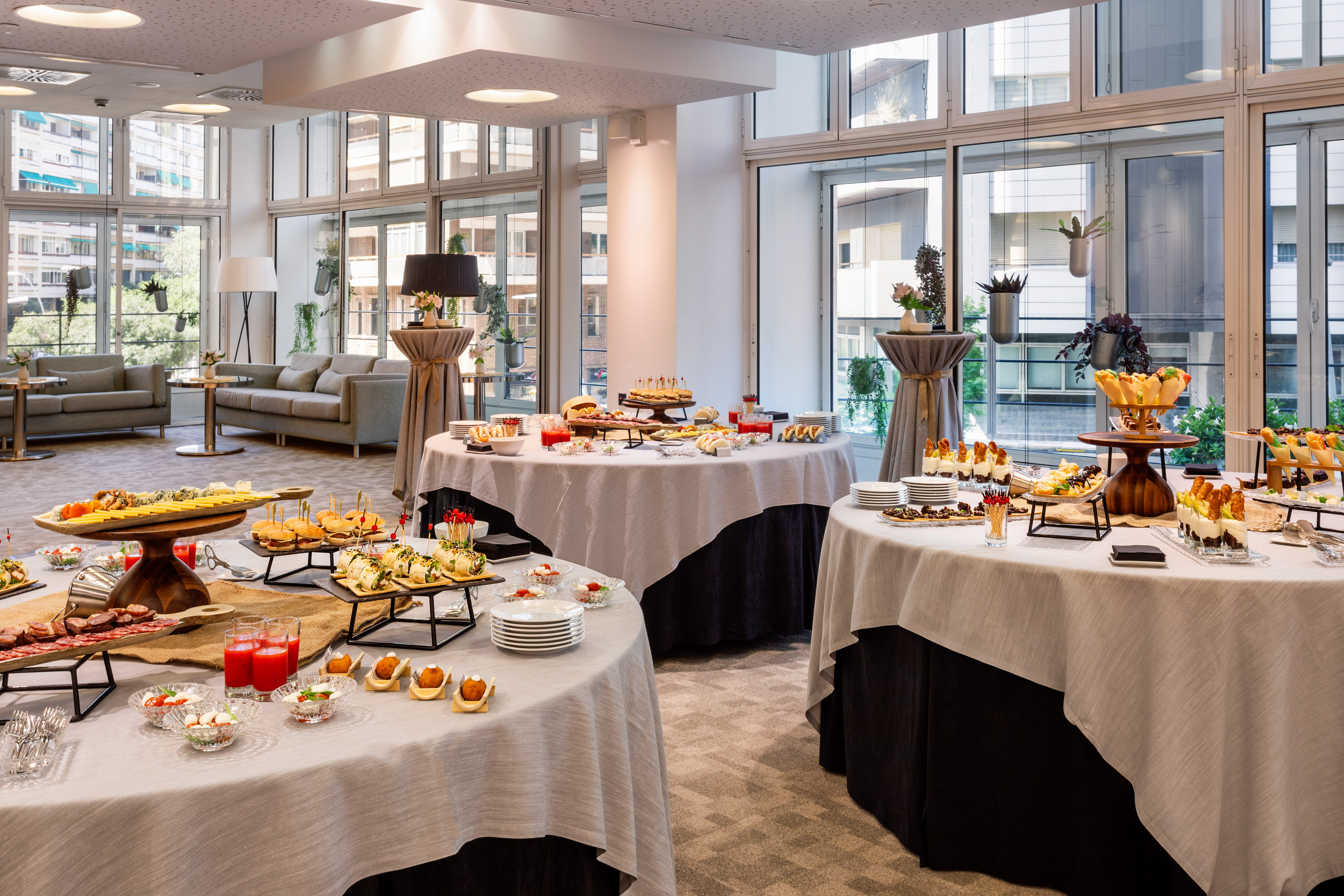Event buffet with diverse appetizers, canapés, and drinks in a modern room.