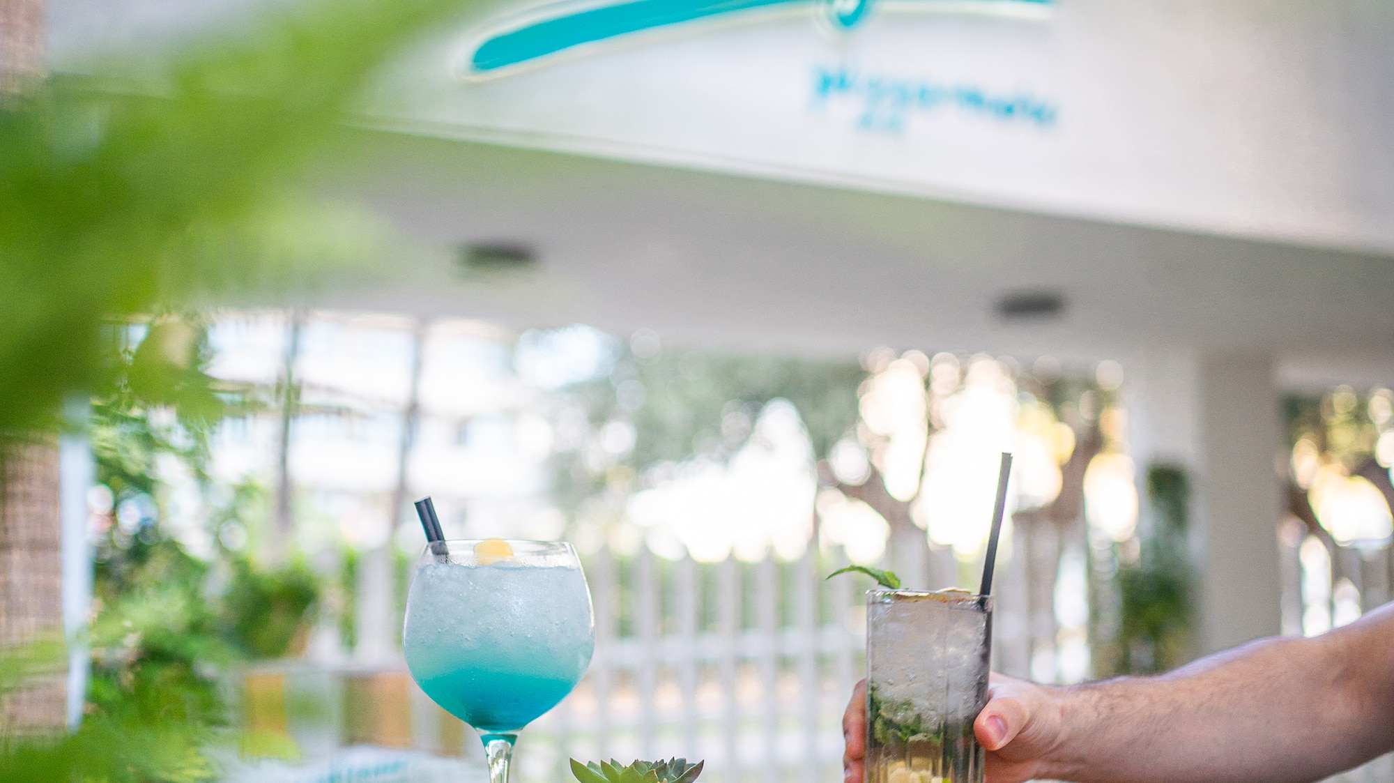 a hand holding a drink with a drink in it