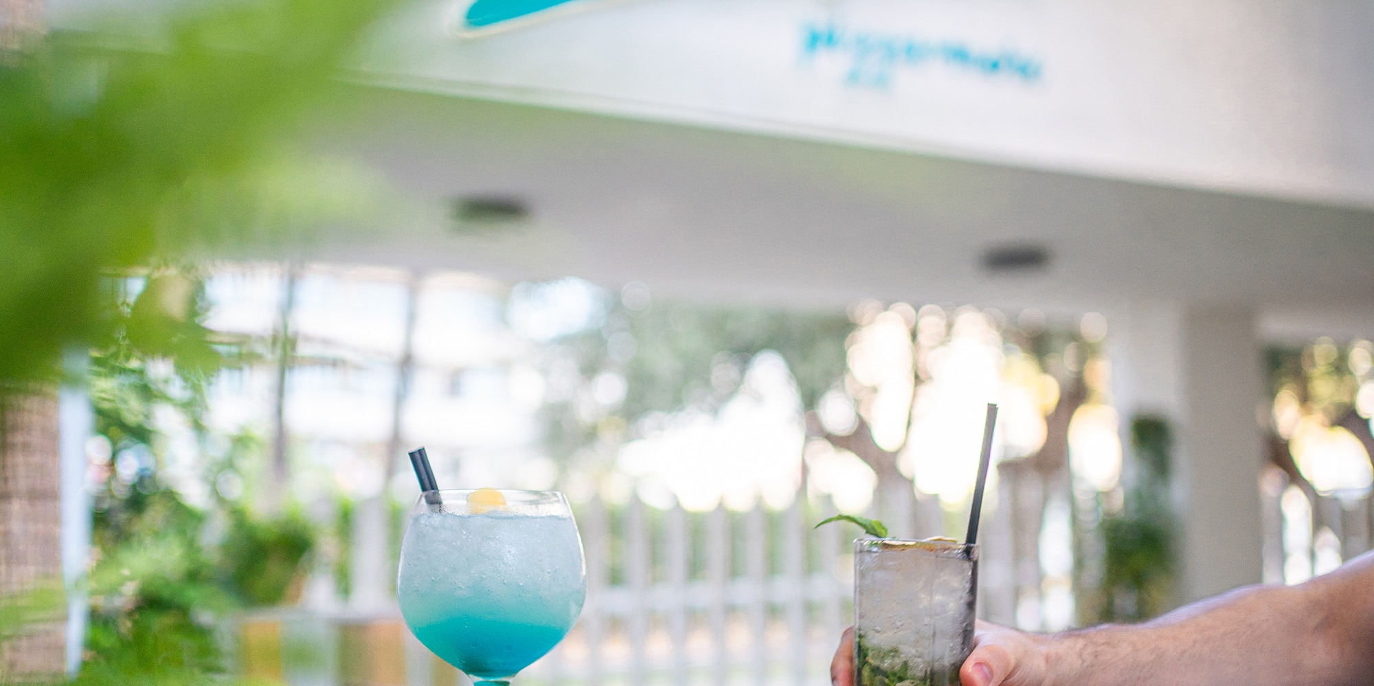 a hand holding a drink with a drink in it