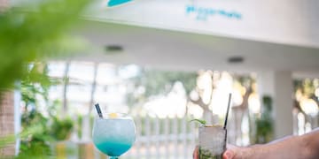 a hand holding a drink with a drink in it