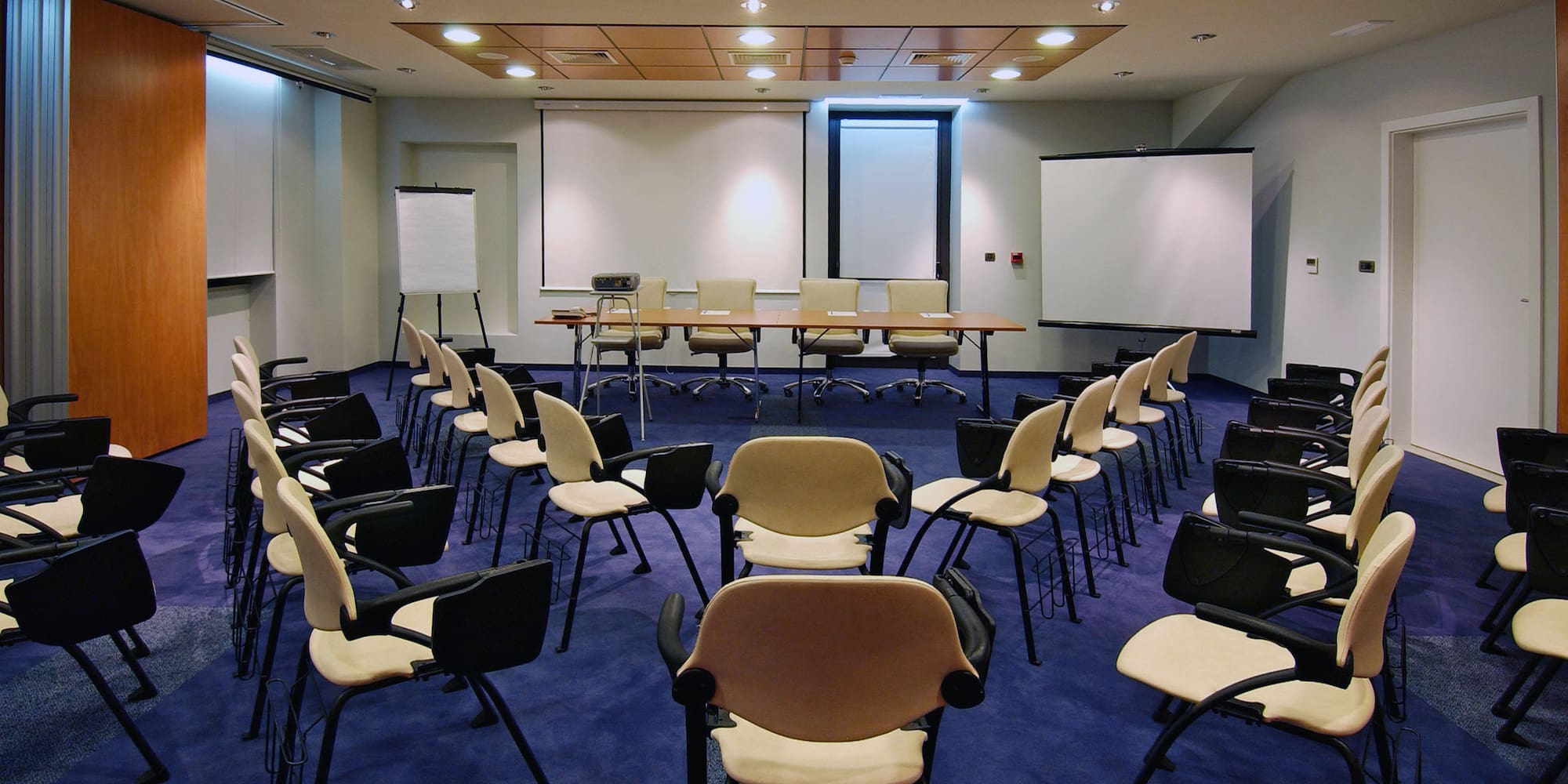 a room with chairs and a projector screen